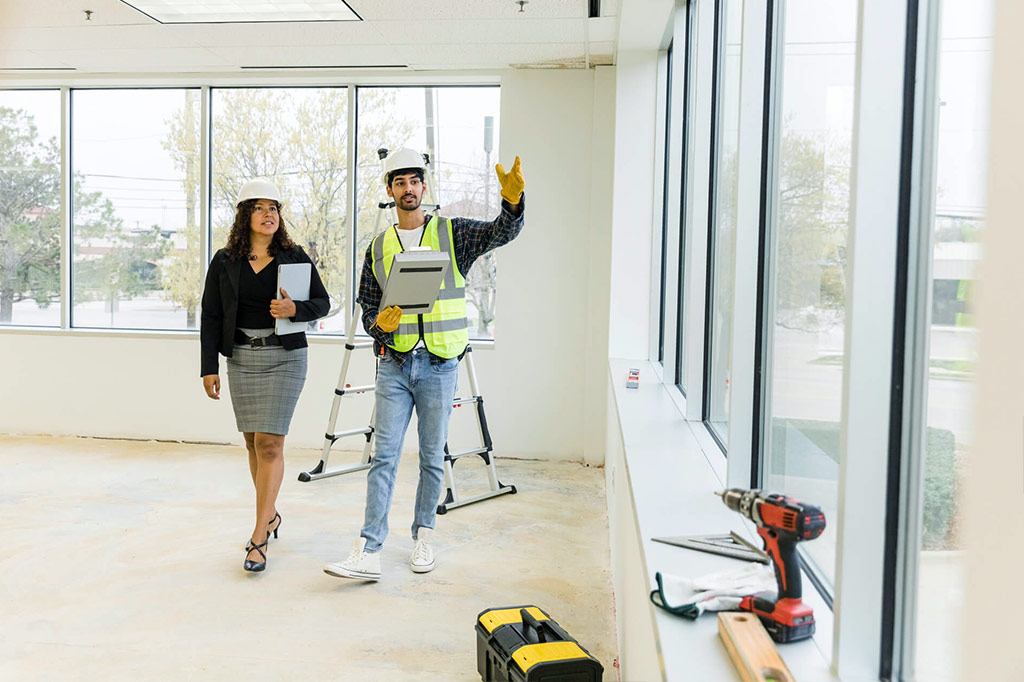 Young man and woman walking through a construction site