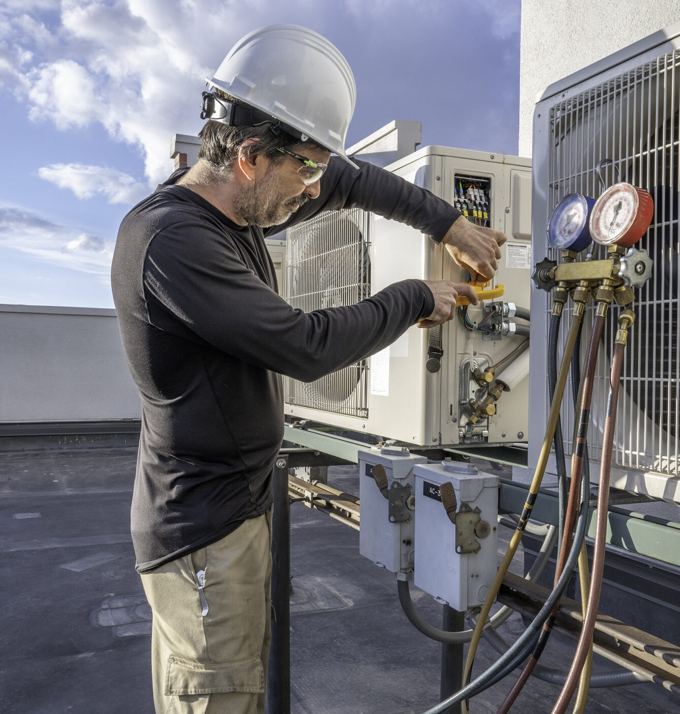 HVAC tech checking a mini split air conditioner amps with a meter.