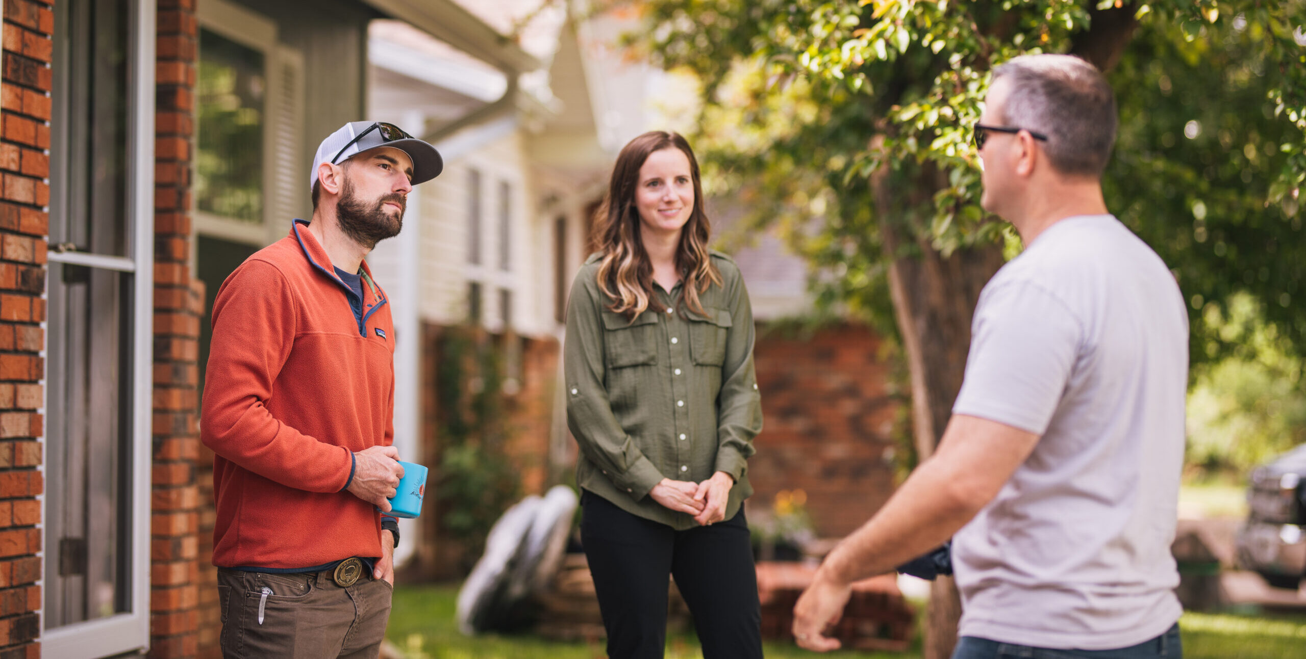 Energy advisor talking to a young couple outside of their home