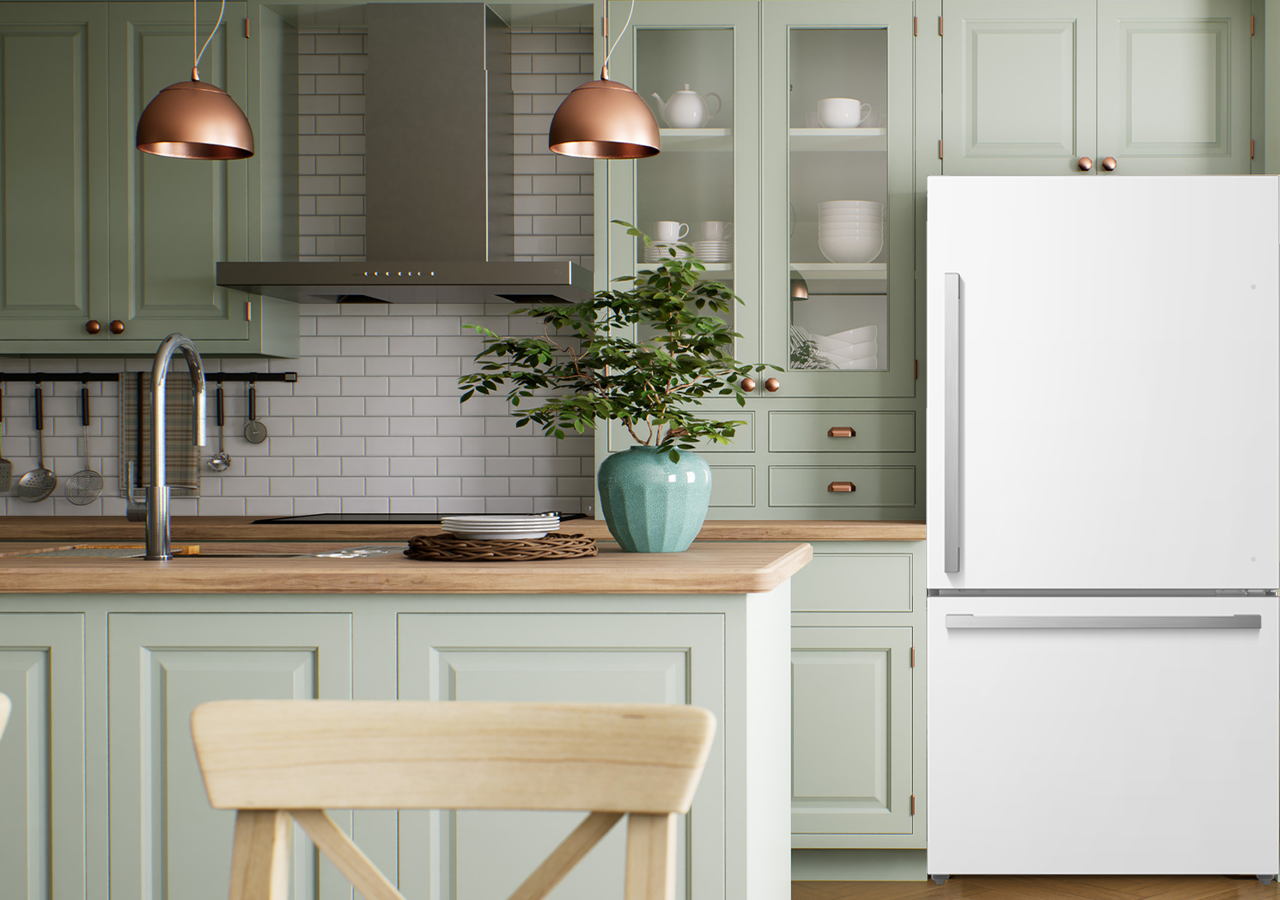 Wide shot of a mint green kitchen with a white refrigerator