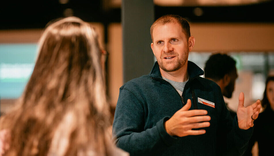 Photo of a man and a woman having a conversation at an event.