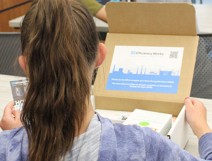 Close up of the back of the head of a young kid opening an Efficiency Works kit.