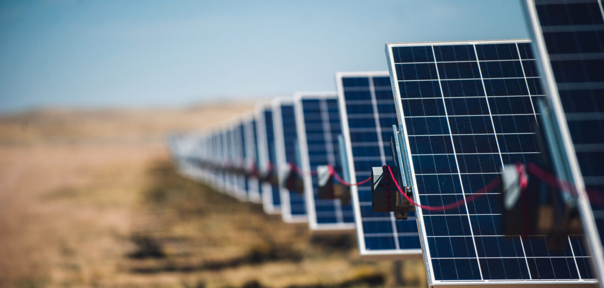 Close up shot of solar panels in a field lined up back to back