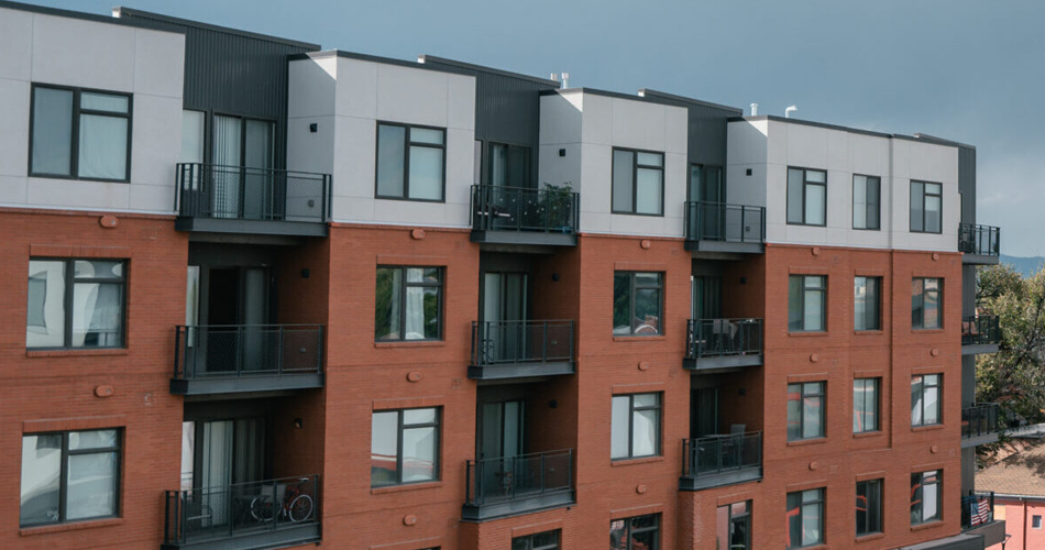 Closeup of exterior of an orange and white apartment building.