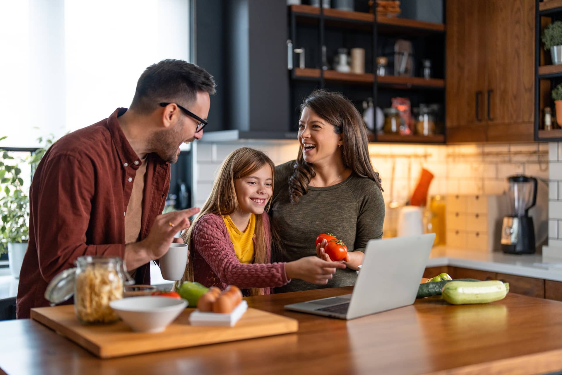 Young girl cooking with her parents at home