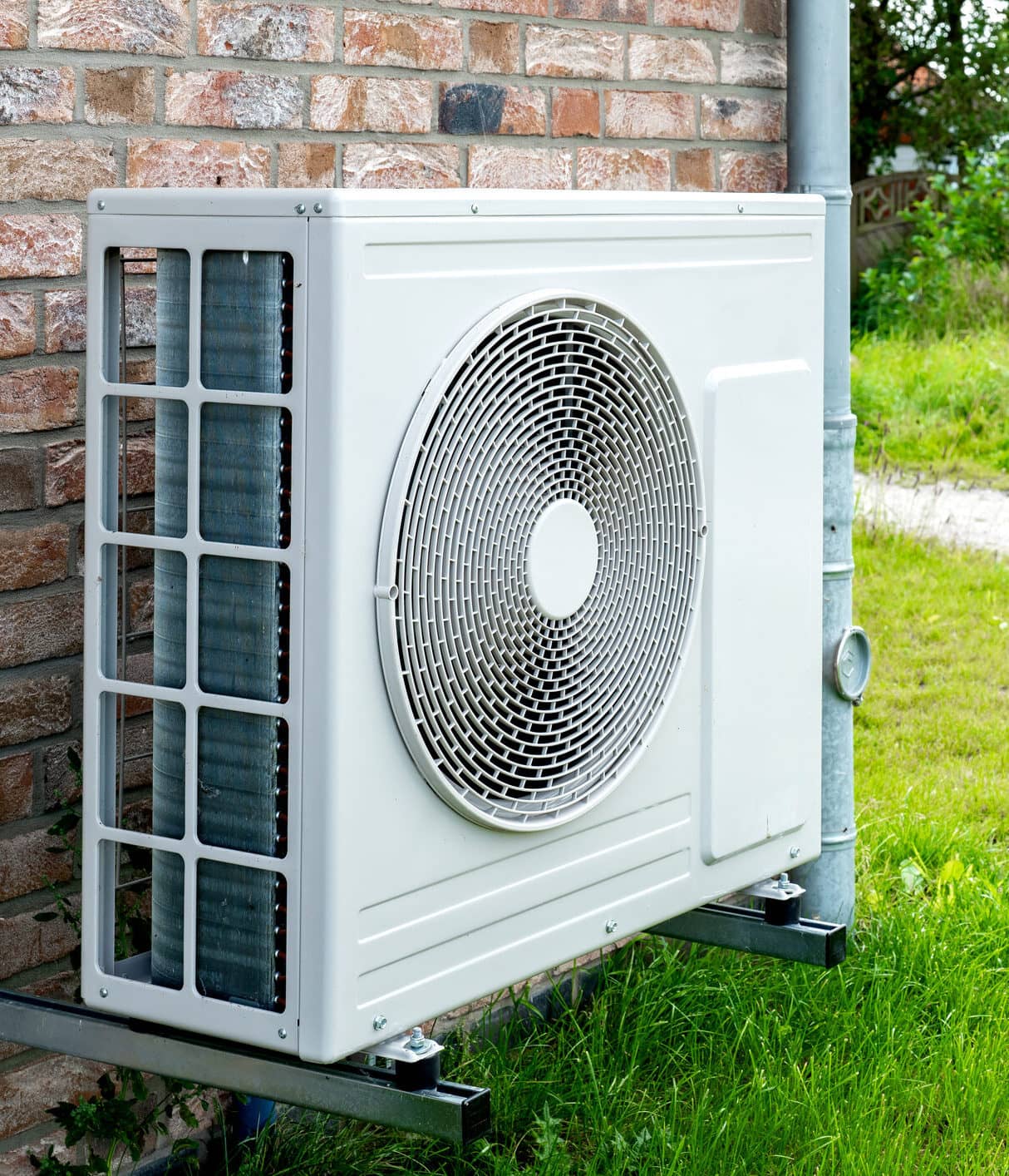 Heat pump, sustainable heating solution for modern homes. Environmentally Friendly Heat Pump Technology in Front of a brick house.