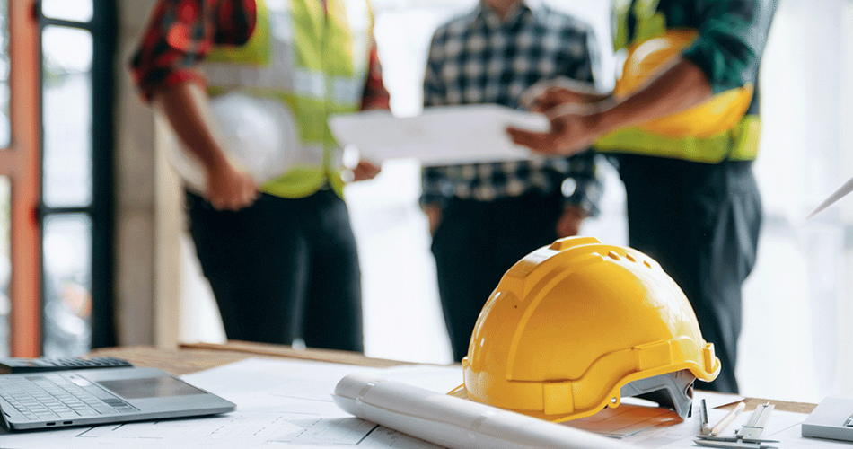 Close up of a yellow hard hat laying on top of a white paper.