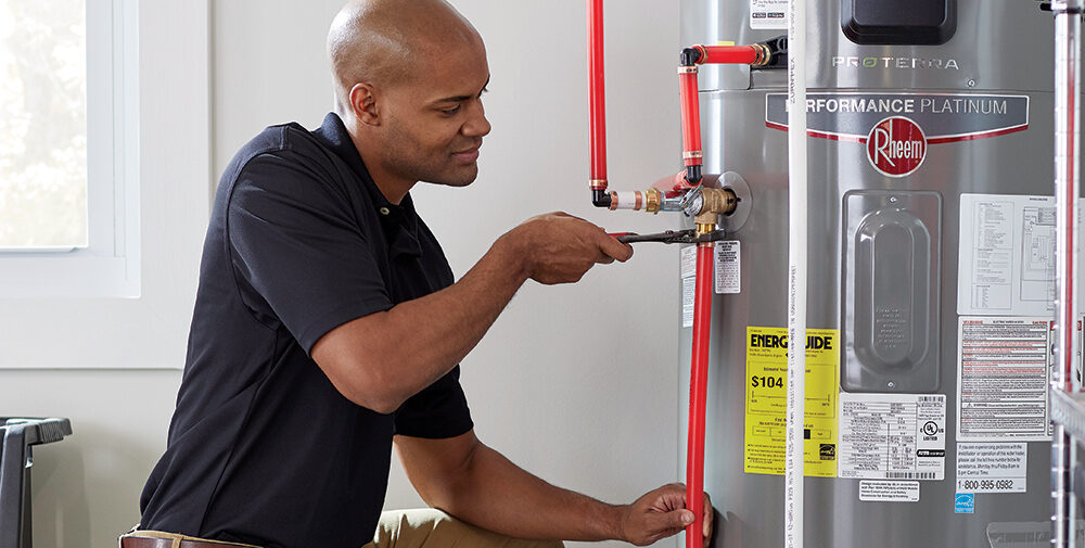 Young man installing a heat pump water heater.