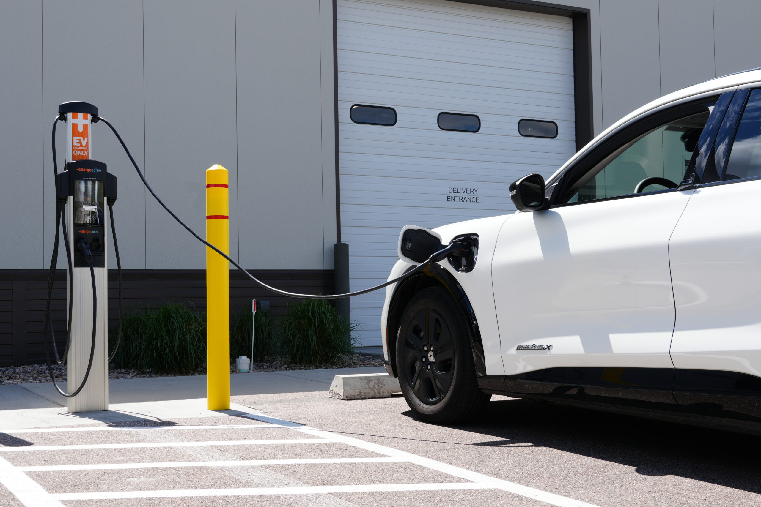 Level 2 EV charger plugged into white electric vehicle