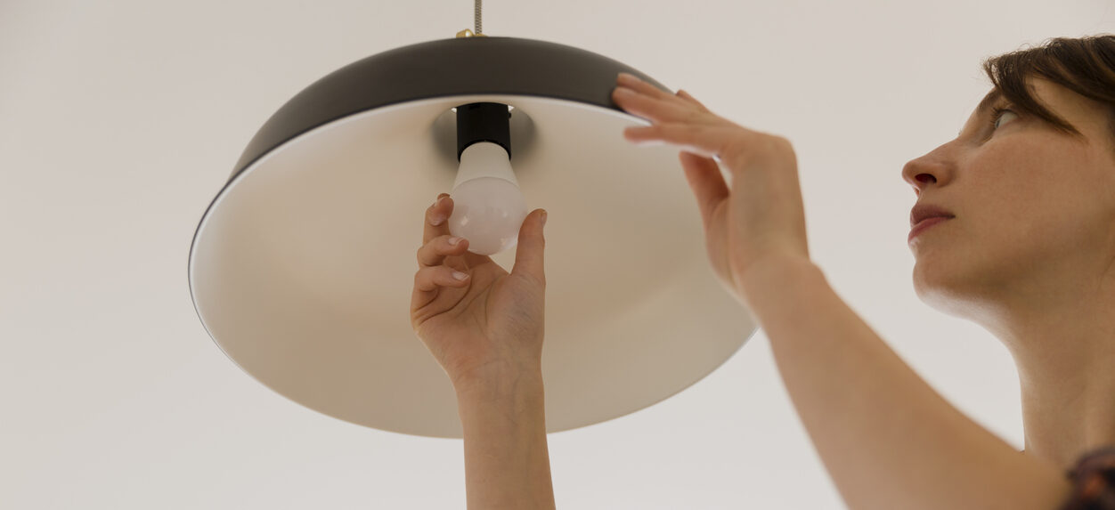 Woman replacing light bulb at home